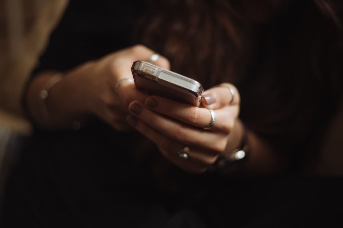 Site WordPress restaurant : erreurs à éviter 4 Une personne consulte son smartphone, illustrant la lecture d'un menu de restaurant sur mobile.