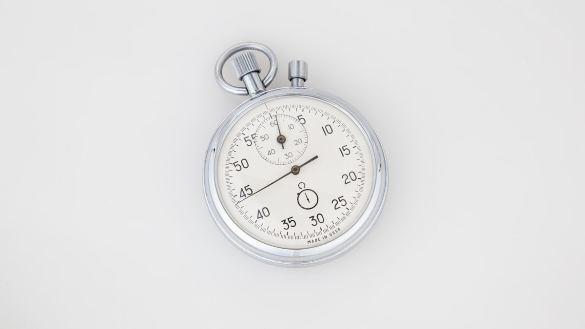 Une montre analogique argentée et blanche, symbolisant la durée d'une refonte de site internet.