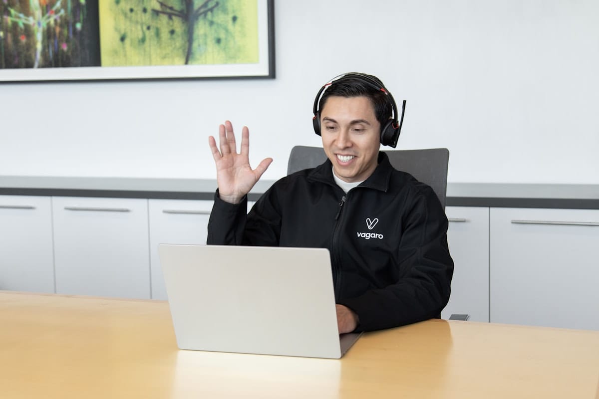 Maintenance WordPress : ce que comprend une offre sérieuse 6 Un homme portant un casque audio assis devant un ordinateur portable, illustrant le support technique en cas de problème.